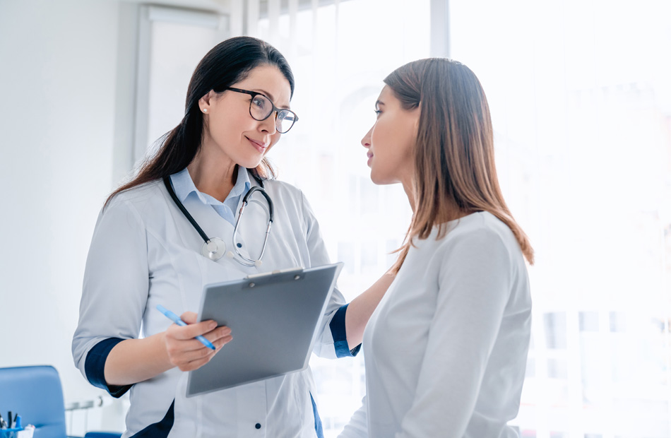 Doctor talking to patient while holding a clipboard during medical consultation