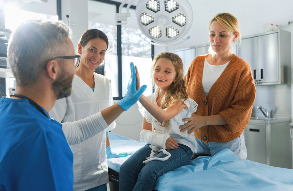 Pediatrician high-fiving a child during an appointment