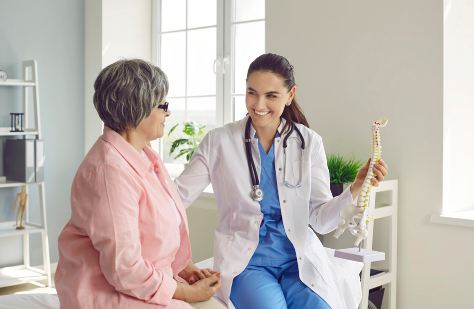 Doctor showing a spine model to a patient during a checkup