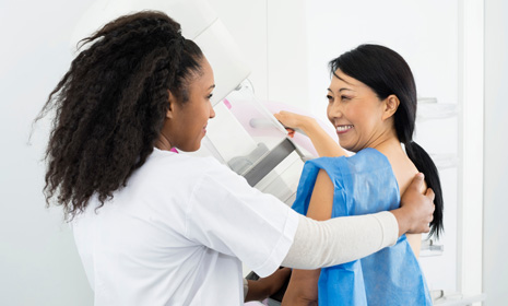 Technician assisting patient during mammogram exam