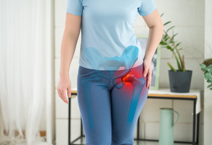 Person holding a painful hip with a hip joint illustration