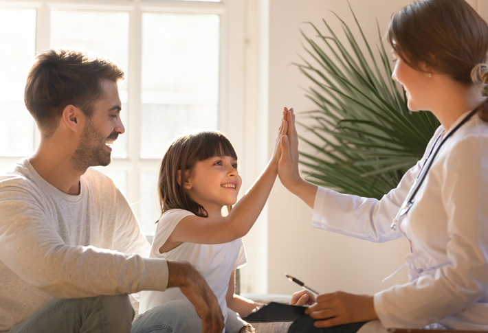 Doctor and child sharing a high five during checkup