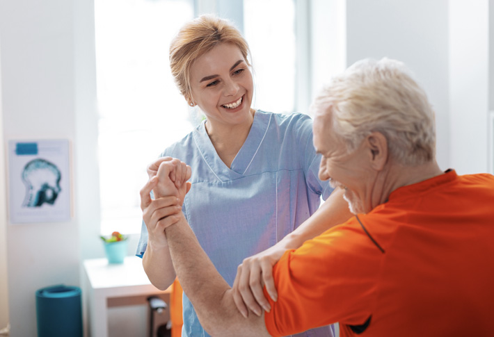 Physical therapist helping a patient with arm exercises