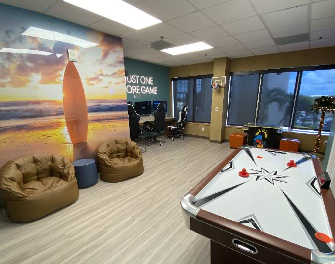 Play room with an air hockey table, video game stations, and bean bag chairs